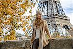 Autumn getaways in Paris. pensive young tourist woman on embankment near Eiffel tower in Paris, France looking into the distance