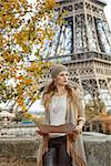 Autumn getaways in Paris. young elegant woman on embankment near Eiffel tower in Paris, France holding map and looking into the distance