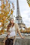 Autumn getaways in Paris. young elegant woman on embankment in Paris, France with map looking into the distance