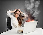 Businesswoman with stressed expression looks at the laptop on fire