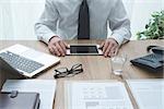 Professional corporate businessman working at office desk and using a digital tablet