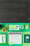 Green eco-friendly desktop with laptop and blank dark copy space, flat lay