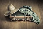 Holiday packing with vintage suitcase and polka dot clothing on hardwood floor.