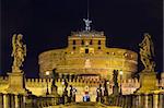 view of angel sculpture on Ponte  Sant'Angelo and Castle of the Holy Angel, Rome. Evening