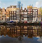 Facades of dutch houses over canal with mirror reflections, Amstardam, Netherlands