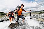 Hikers crossing mountain river