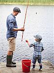 Father with son fishing on jetty