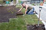 Man laying turf in garden