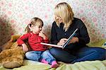 Mother reading book to her daughter