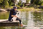 Woman on jetty with dog fishing