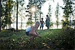 Family walking, girl picking flowers, Dalarna, Sweden