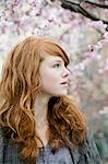 Young woman with blossom in cherry trees around