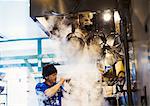 The ramen noodle shop. A chef working in a kitchen with steam rising from the pots of noodles.