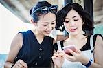 Two young women looking at a mobile phone.