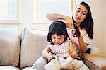 Family home. A mother combing her daughter's hair.