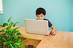 A boy using a computer in a classroom.