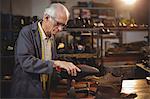 Shoemaker repairing a shoe in workshop