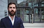 Portrait of businessman standing outside office