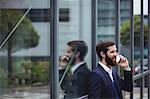 Businessman talking on mobile phone outside office