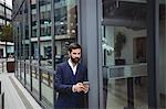 Businessman using mobile phone outside office