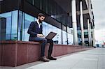 Businessman using mobile phone outside office