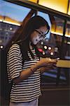 Attentive young woman using digital tablet on street