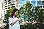 Young woman using mobile phone on street