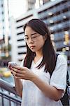 Attentive woman text messaging on mobile phone