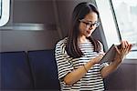 Young woman using digital tablet while travelling in ship