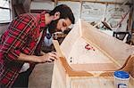 Man preparing wooden boat frame in boatyard