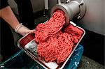 Minced meat coming out from grinder at butchers shop