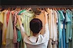 Woman selecting a clothes from hanger at boutique store