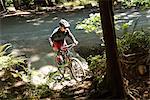 Male cyclist cycling in forest on a sunny day