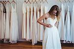 Beautiful woman trying on wedding dress in a shop in studio