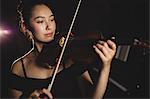 Female student playing violin in a studio
