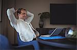 Happy businessman sitting in office