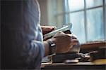 Mid-section of craftswoman working in workshop