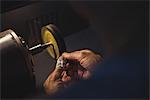 Hands of craftswoman working on a machine in workshop