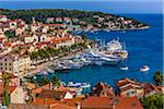 Overview of clay tile rooftops and luxury yachts docked in marina at the Old Town of Hvar on Hvar Island, Croatia