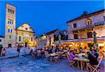 People dining at restaurant in St Stephen's Square at dusk with Cathedral of St Stephen in the Old Town of Hvar on Hvar Island, Croatia