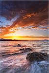 Scenic view of surf crashing against the rocks at sunset at Cala Sabina Beach in Golfo Aranci in the Province of Sassari in Sardinia