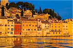 Waterfront with the sun reflecting on the buildings of the fishing port city of Rovinj on the north Adriatic Sea in Istria, Croatia