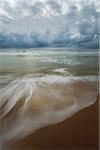 Cloudy sky over the Tyrrhenian Sea and blurred surf on the sands of the beach at San Felice Circeo in the Province of Latina in Lazio, Italy