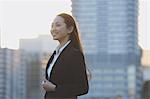 Portrait of young Japanese businesswoman by a river downtown Tokyo