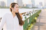 Portrait of young Japanese businesswoman by a river downtown Tokyo