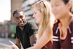 Three adult friends talking in skatepark