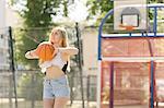 Young woman practising on basketball court
