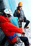 Ice climbers in ice cave preparing climbing equipment