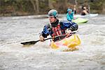 Young male kayaker paddling River Dee rapids