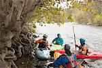 Male and female kayakers having team talk on River Dee, Llangollen, North Wales